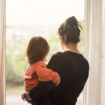 Mother and son looking out of window